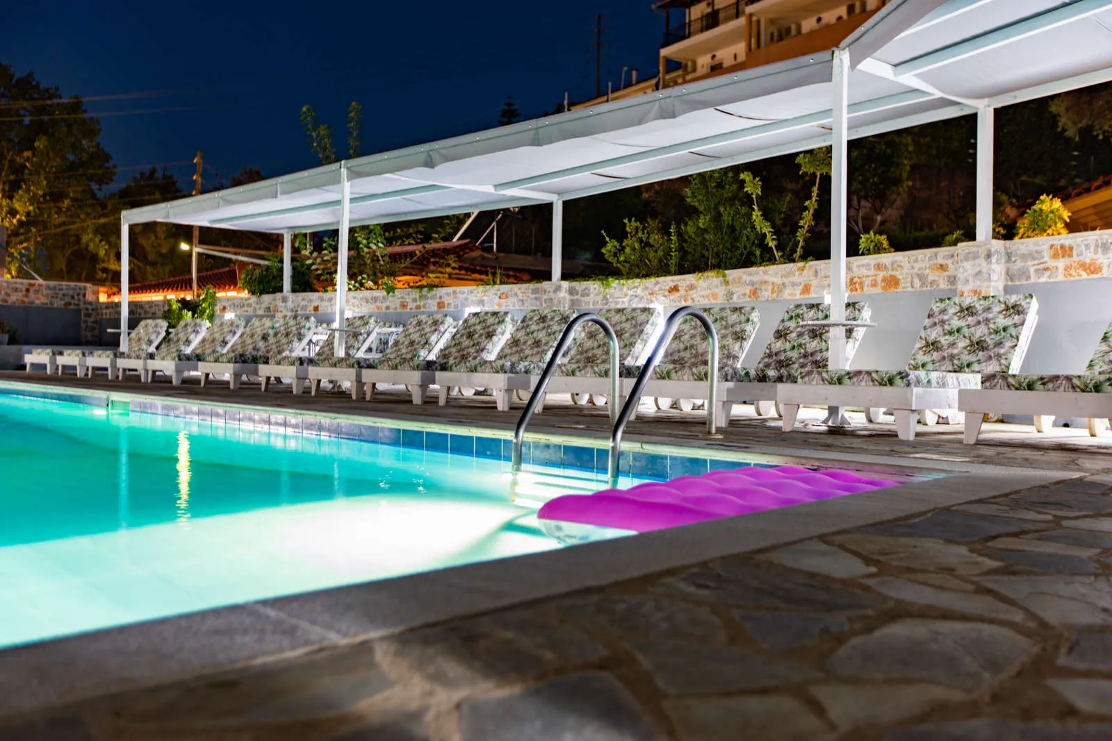 The pool and sunbeds lit up at night