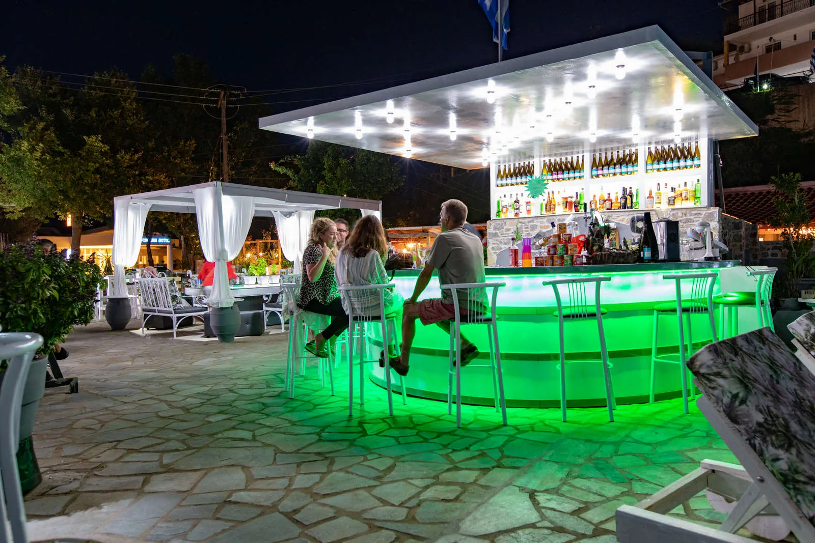 The round pool bar glowing green at dusk